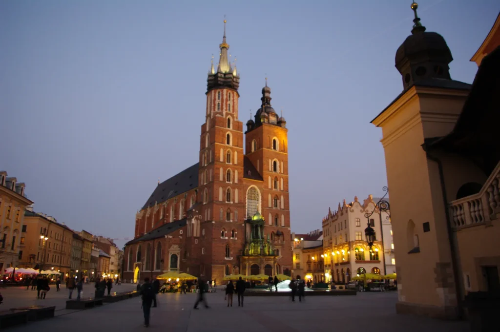 Stadtführung auf dem Rynek Główny in Krakau mit Blick auf die Marienkirche und die Tuchhallen bei Sonnenuntergang