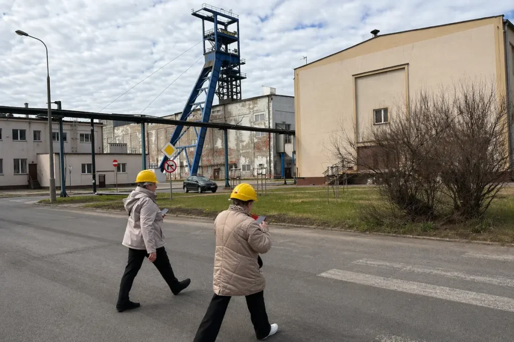 Besucher mit Schutzhelmen vor dem Förderturm im Salzbergwerk Kłodawa in Polen