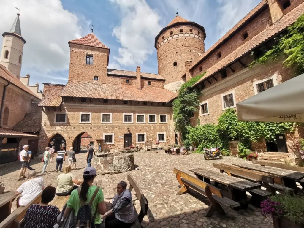 Polen Rundreisen kleine Gruppen: Eine Reisegruppe besichtigt den Innenhof der Burg Reszel (Rößel) in Masuren mit deutschsprachigem Reiseleiter.