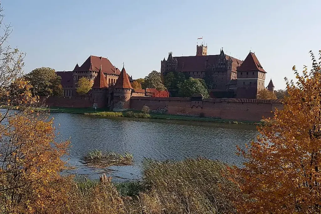 Hochburg Marienburg (Malbork) – Herbstpanorama über der Nogat mit Backsteinmauern und Türmen des Deutschen Ordens