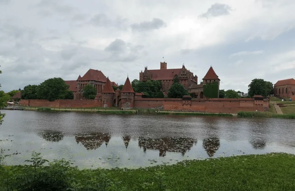 Marienburg Besichtigung deutschsprachig: Die imposante Ordensburg Marienburg am Ufer der Nogat – ein Highlight jeder Polen Rundreise.