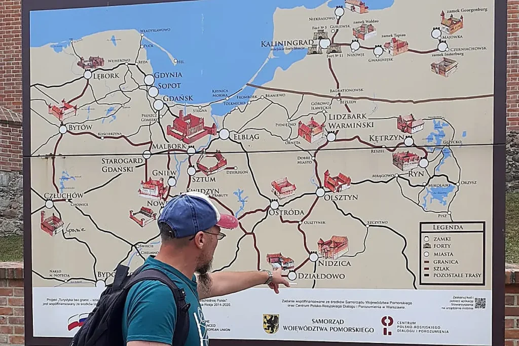 Reiseleiter Wojciech Soroka plant eine individuelle Route auf der Landkarte der pommerschen Schlösser und Burgen.